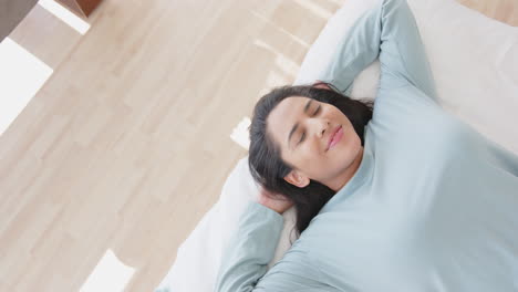 relaxing on bed, mature asian woman smiling and enjoying peaceful spa moment, at home, copy space