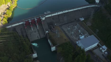 aerial view of mazegawa dam, tilt reveal at sunrise to mountains of gifu, japan