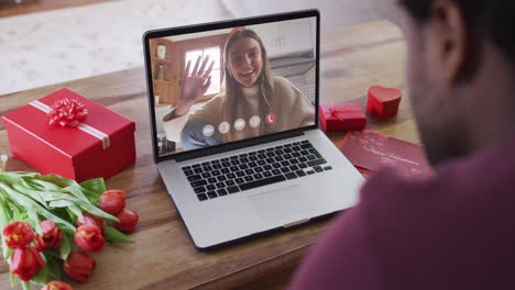 Happy-caucasian-woman-waving-and-making-valentine's-day-video-call-on-laptop