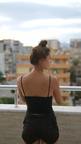 young woman on balcony overlooking city