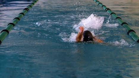 fit female swimmer doing the back stroke in swimming pool