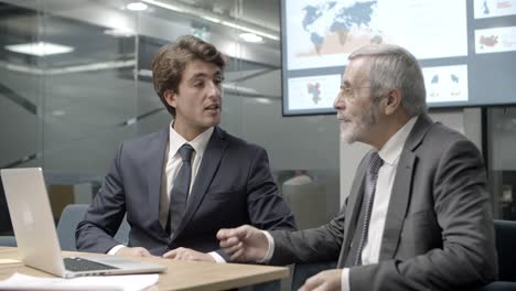 Confident-businessmen-communicating-during-meeting
