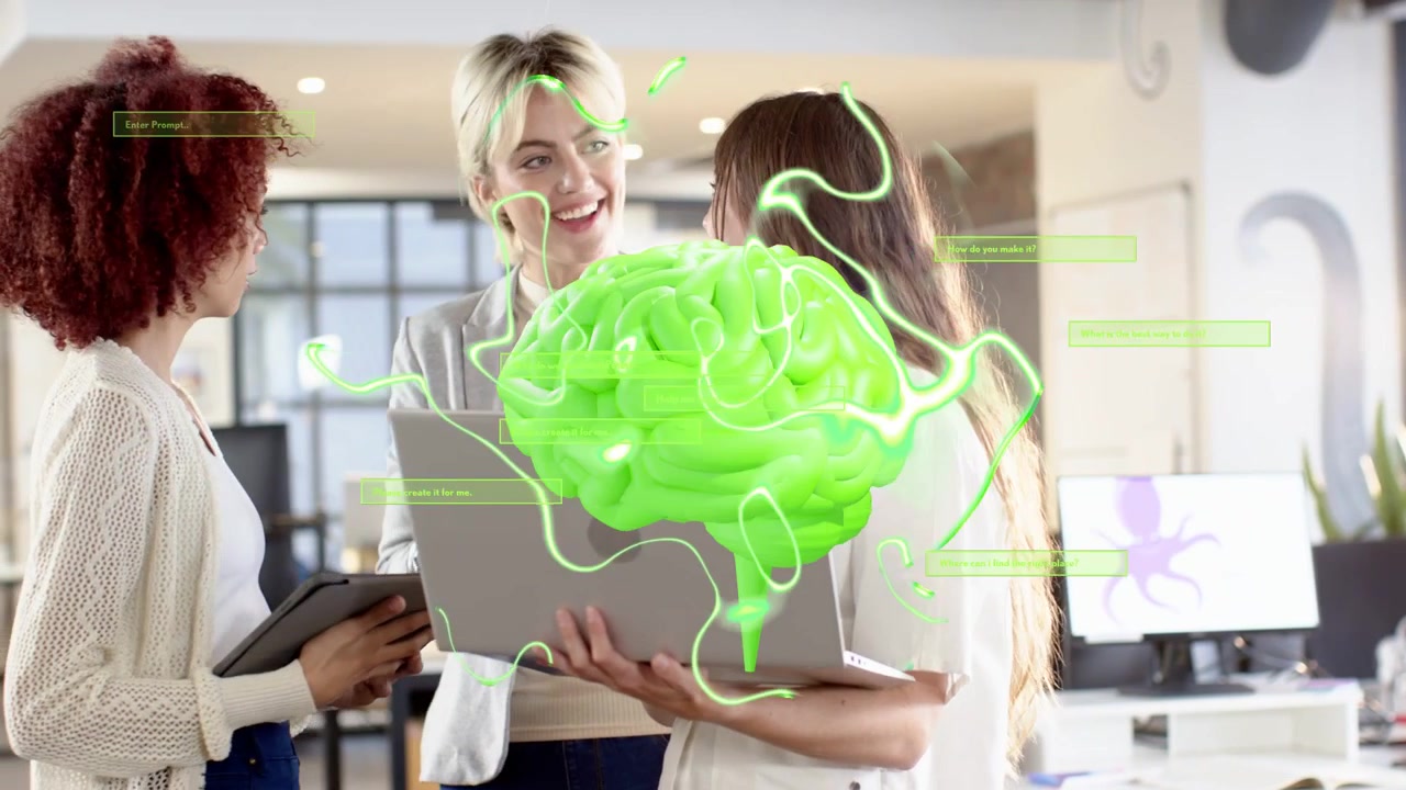 Tre donne gesticolano verso un laptop e un tablet, creando un cervello AR verde neon mentre lavorano a una demo tecnologica.