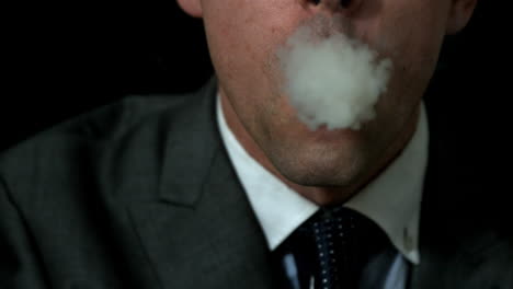 businessman smoking his cigar on black background