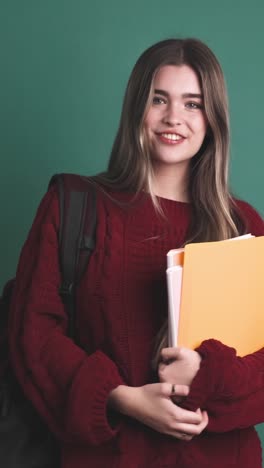 happy young woman student standing with books