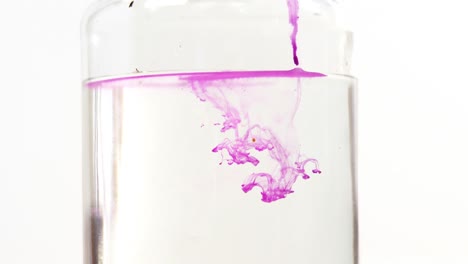 pink color liquid spreading in water