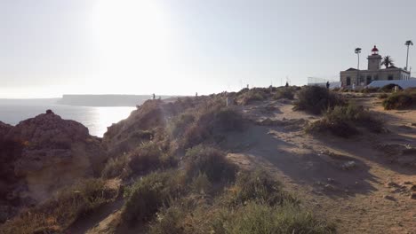 Faro-De-Ponta-Da-Piedade-Y-Acantilados-Distantes-Recortados-Por-La-Luz-Del-Sol,-Portugal