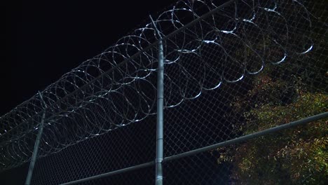 cárcel cercada con alambre de púas por la noche