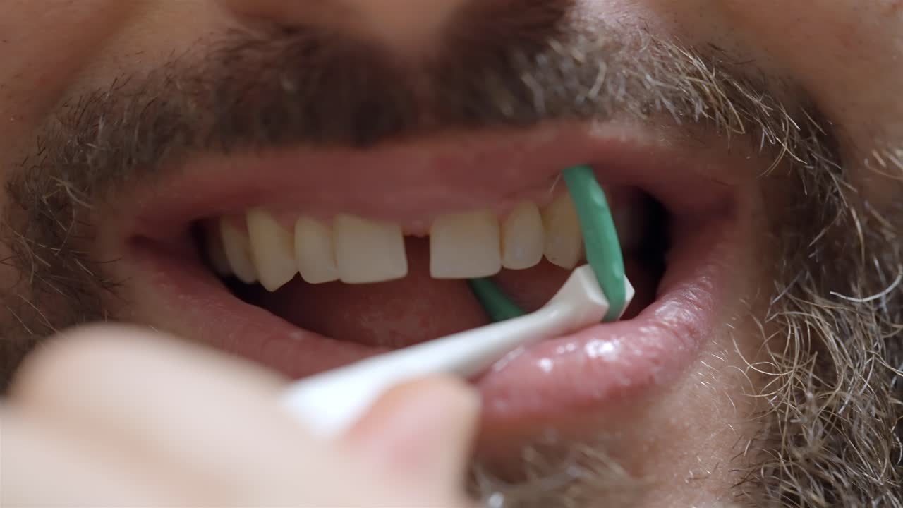 Healthy Gums Focus: Man Flossing Between Teeth with Floss Holder