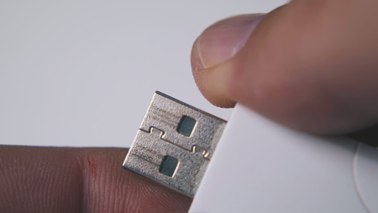 persona abre una unidad flash usb moderna en un fondo claro