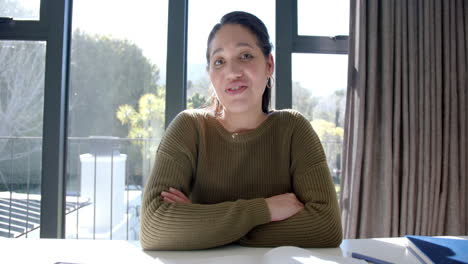 Happy-biracial-woman-in-sweater-having-video-call-in-sunny-living-room-at-home