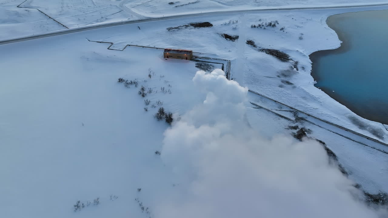 rápido drone dolly disparó a través del humo blanco de las instalaciones geotérmicas de myvatn en el paisaje nevado de islandia