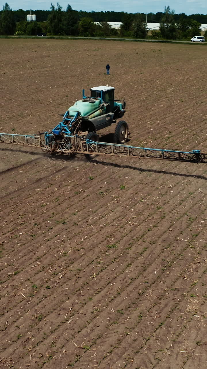Treatment of fields with pestecides. Aerial view of tractor spraying pesticides on field