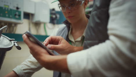 Industrieingenieure-überprüfen-Die-Wartung-Der-Geräte.-Männliche-Hände-Halten-Tablet-Nahaufnahme.