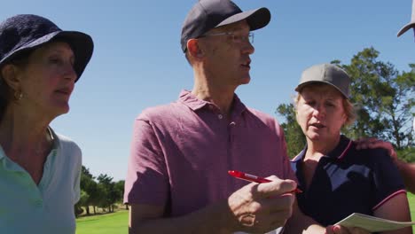 Caucasian-senior-couple-discussing-and-writing-golf-score-on-scorecard-at-golf-course