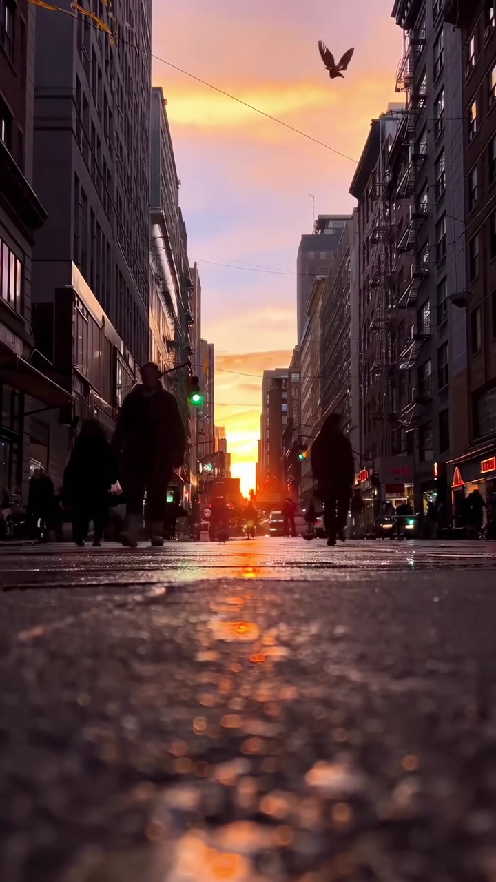 Tramonto urbano con persone in silhouette e riflessi sulla strada