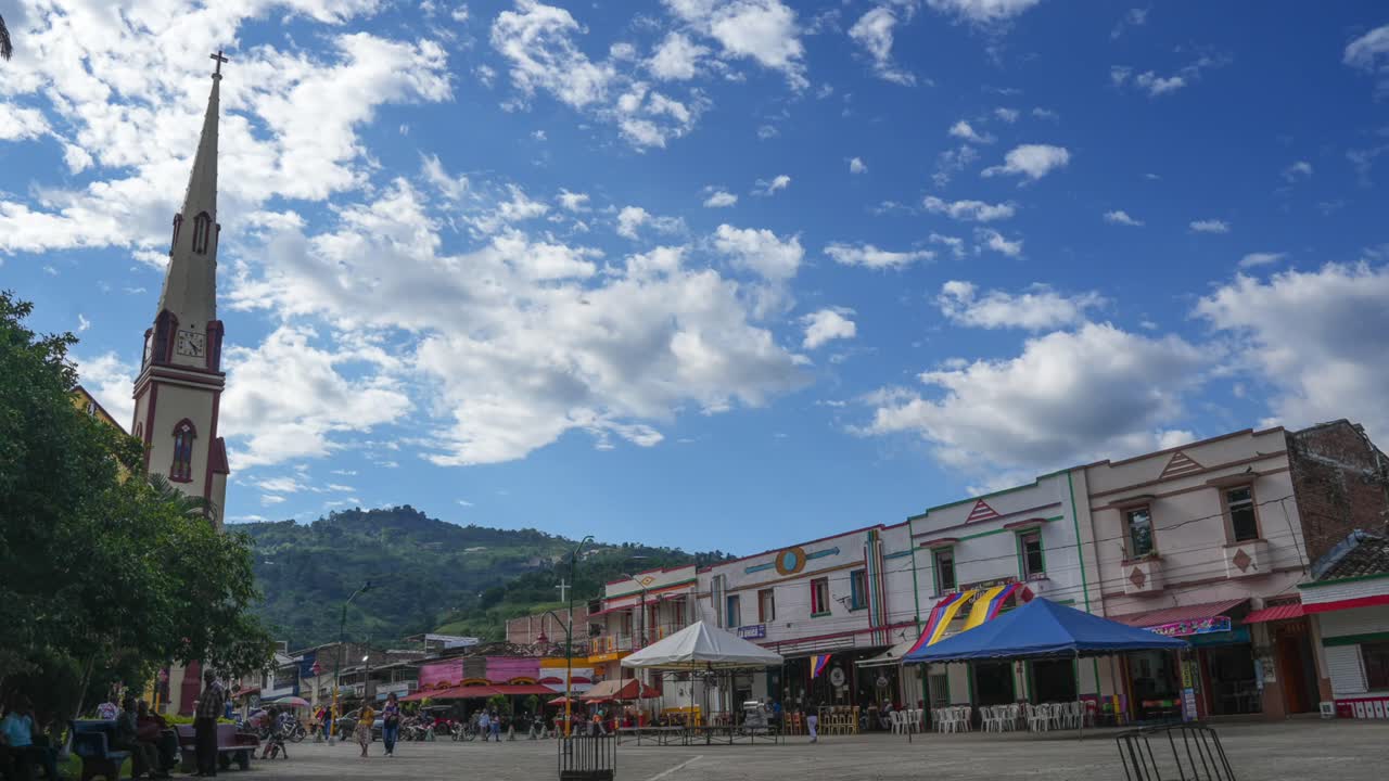Town square with church and buildings under a cloudy sky
