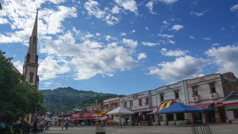 town square with church and buildings under a cloudy sky