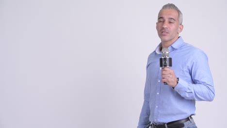 hombre de negocios persa maduro con micrófono