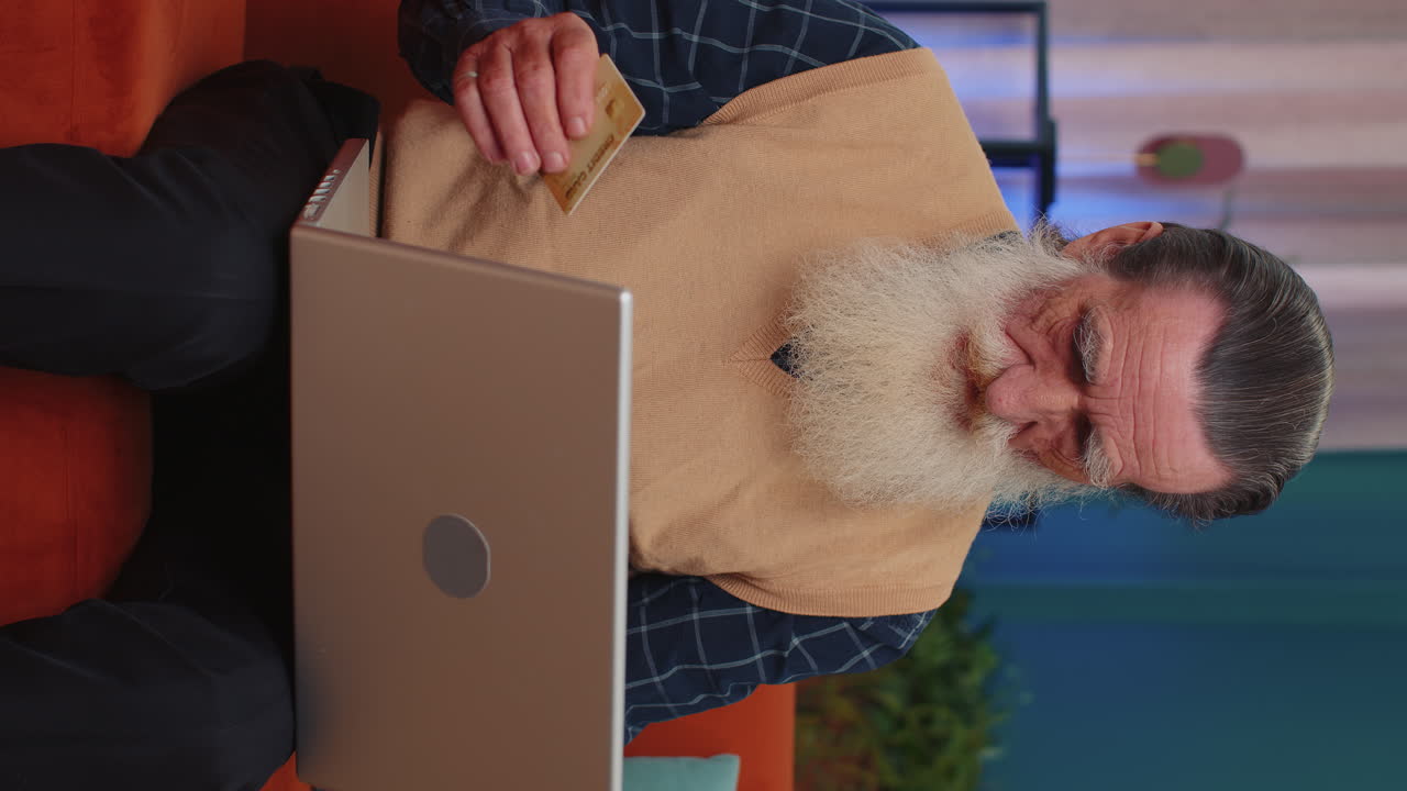 hombre mayor usando tarjeta de crédito y portátil, transfiriendo dinero, comprando compras en línea