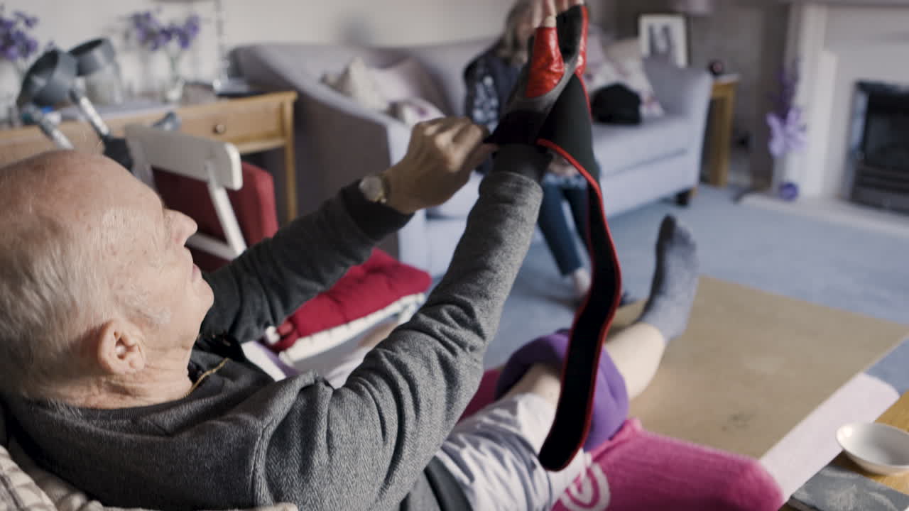 Senior man doing leg stretches with assistance at home