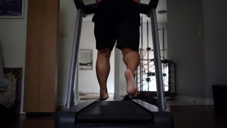 a person running barefoot on a treadmill indoors