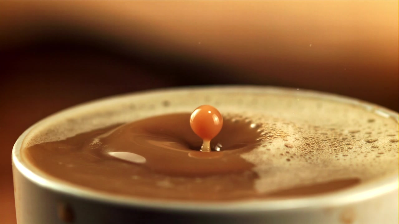 Goccia al rallentatore che si tuffa in una bevanda al caffè.