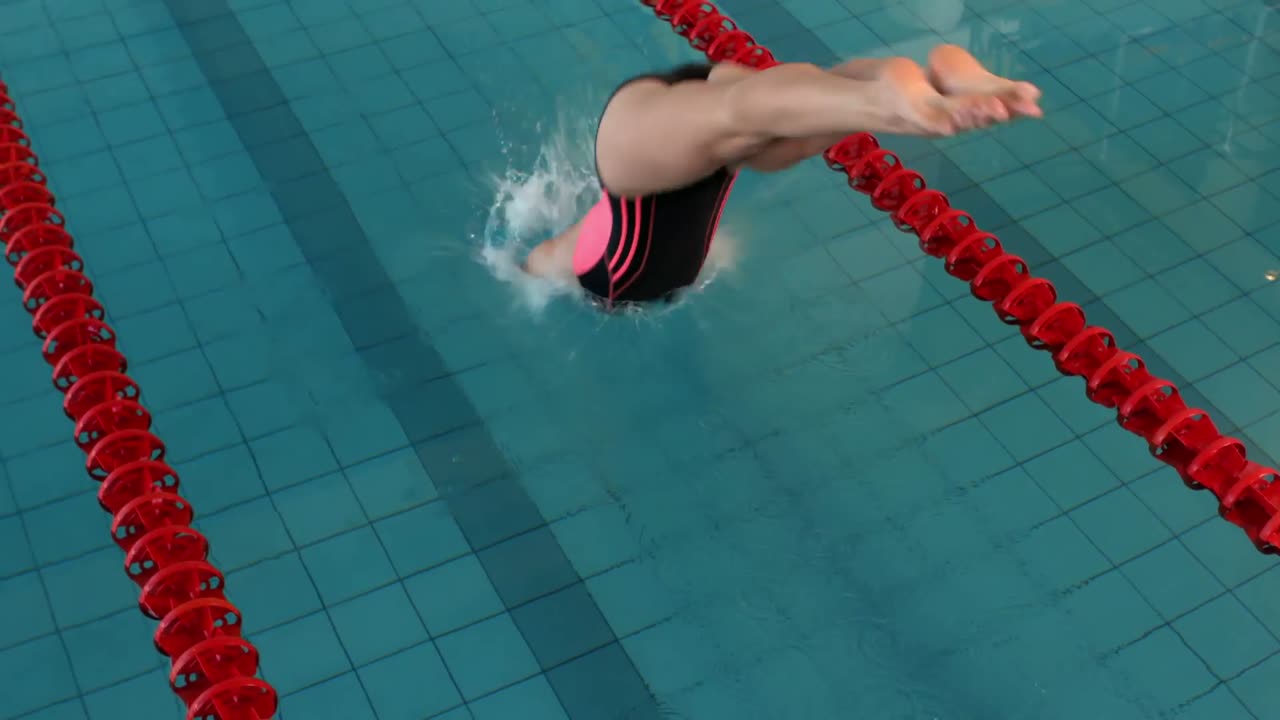 Fit woman swimmer diving into pool