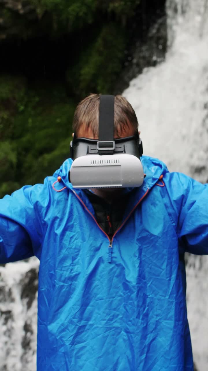 Man wearing VR headset at waterfall