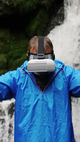 man wearing vr headset at waterfall