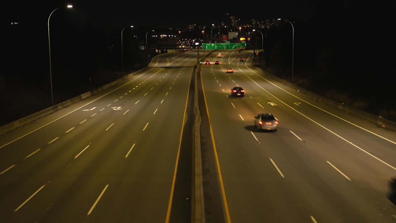 밴쿠버의 스카이라인을 배경으로 밤에 캐나다 고속도로의 바쁜 교통