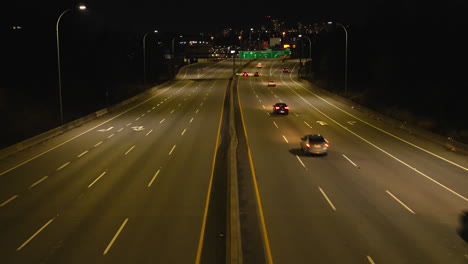 busy traffic on canadian highway during night with skyline of vancouver in background