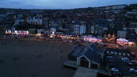 Un-Dron-Aéreo-Se-Movió-Hacia-Adelante-Sobre-Casas-Junto-A-La-Playa-En-La-Ciudad-De-Scarborough,-North-Yorkshire,-Inglaterra,-Durante-La-Noche.