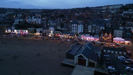 aerial drone forward moving shot over beachside houses in the town of scarborough, north yorkshire, england during evening time