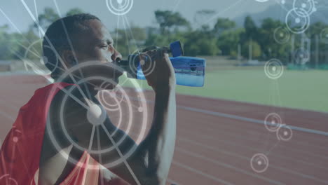 animation of network of connections over male athlete with drinking water on running track