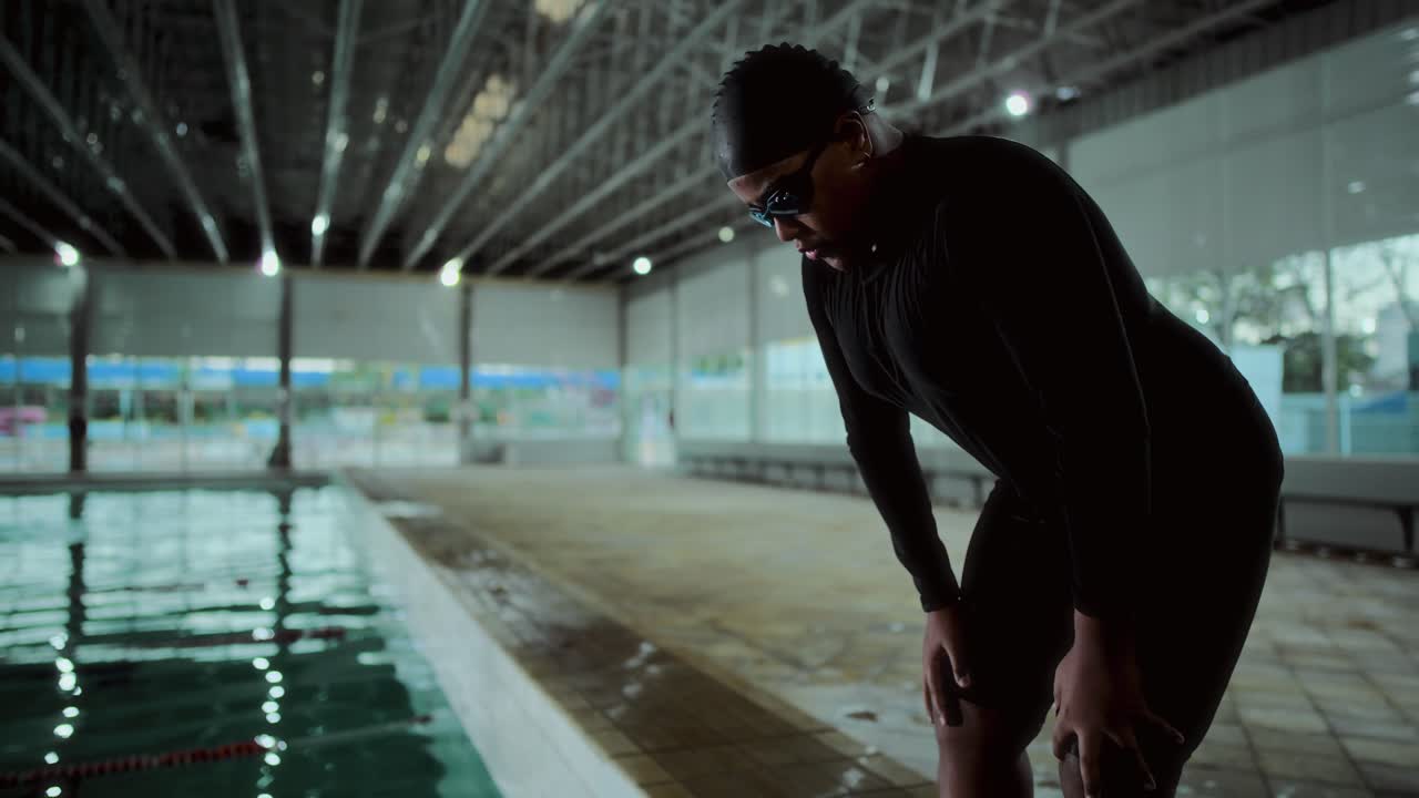 Swimmer preparing or resting at an indoor swimming pool