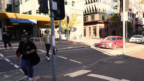 people crossing street with cars in background