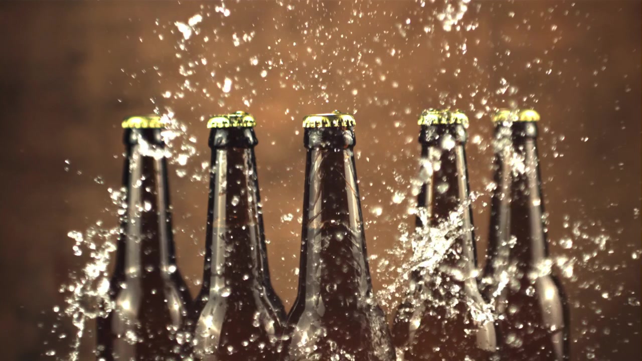 Wasser spritzt in Zeitlupe um kalte Bierflaschen