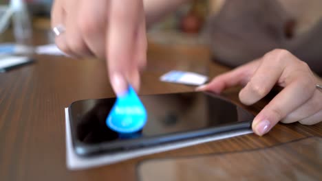 Crop-female-technician-removing-dust-from-smartphone-screen