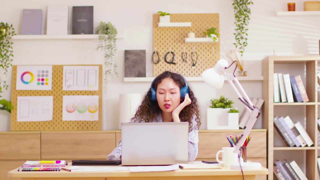 타임 스: 아시아의 매력적인 여성, 열심히 일하고, 음악을 듣고, 바고, 집 사무실에서 잘 설계된 배경 작업 공간과 함께 멀티 태스킹. 타임스: 타임 플라이스는 열심히 작업하는 라이프 스타일 개념.