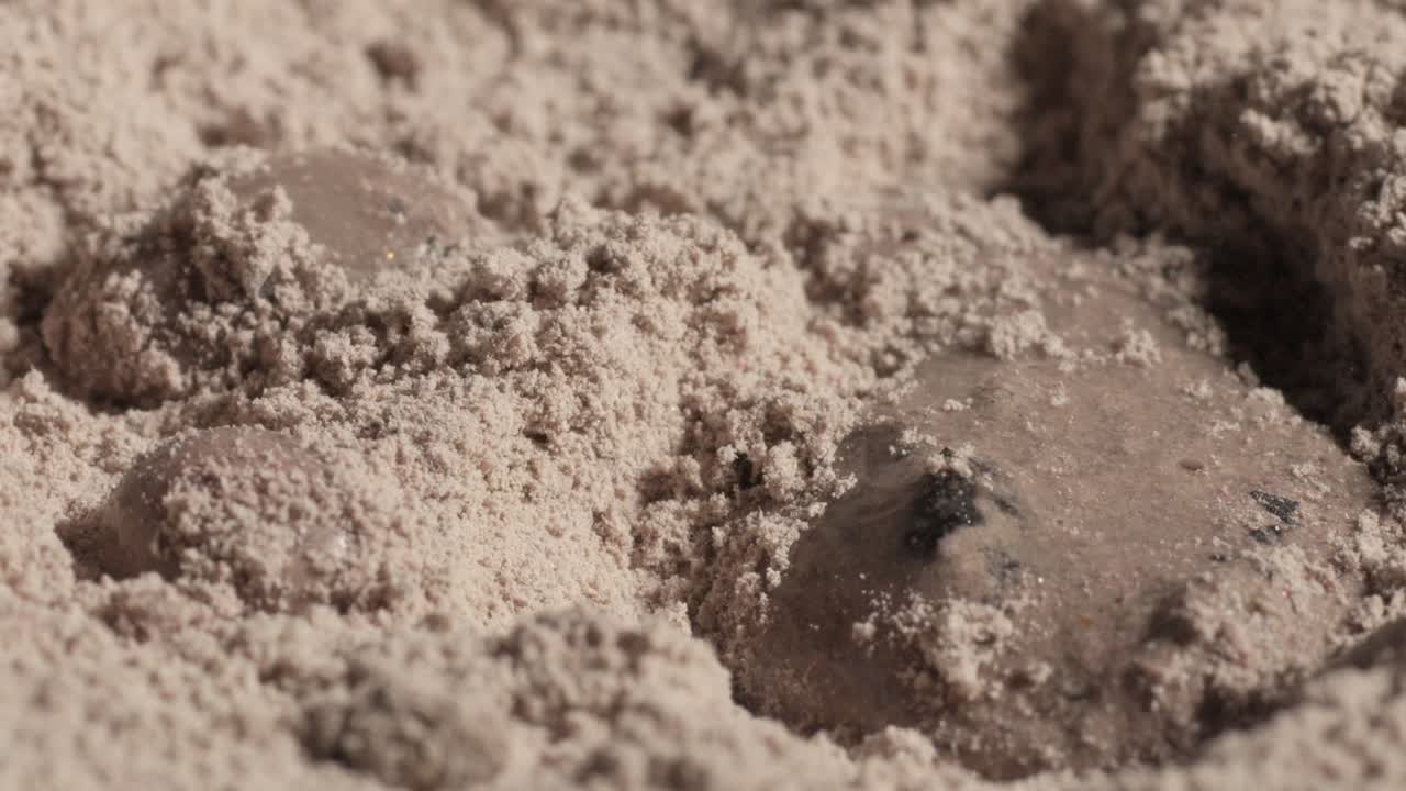 Wet dough ball partially covered in fine, dry flour, close-up macro view