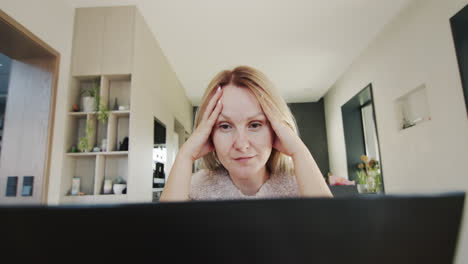 unhappy woman sitting at laptop monitor. wide lens shot