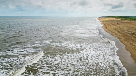 Eine-Luftdrohne-Enthüllt-Die-Harmonische-Begegnung-Eines-Sandstrandes-Und-Des-Ruhigen-Rauschens-Sanfter-Wellen-Entlang-Der-Küste