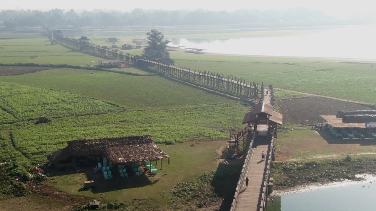 Persone che camminano sul lungo ponte U-Bein in una mattina di sole a Mandalay, in Myanmar