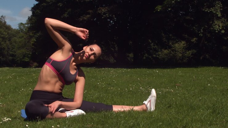 Sporty brunette strækker ud på græs