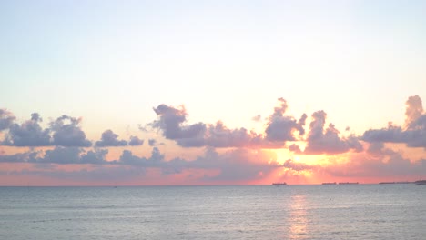 sunset over the ocean with ships