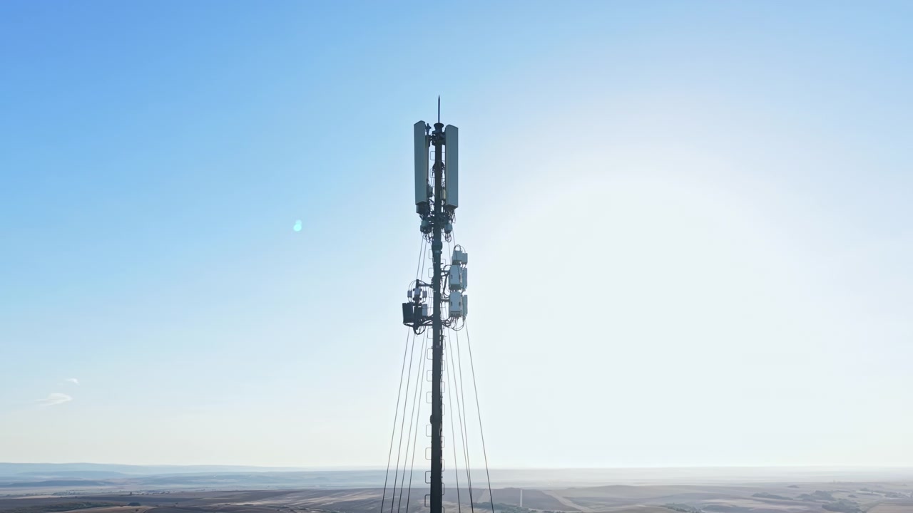 Torre cellulare si erge alta contro il cielo sereno di giorno in un ambiente rurale