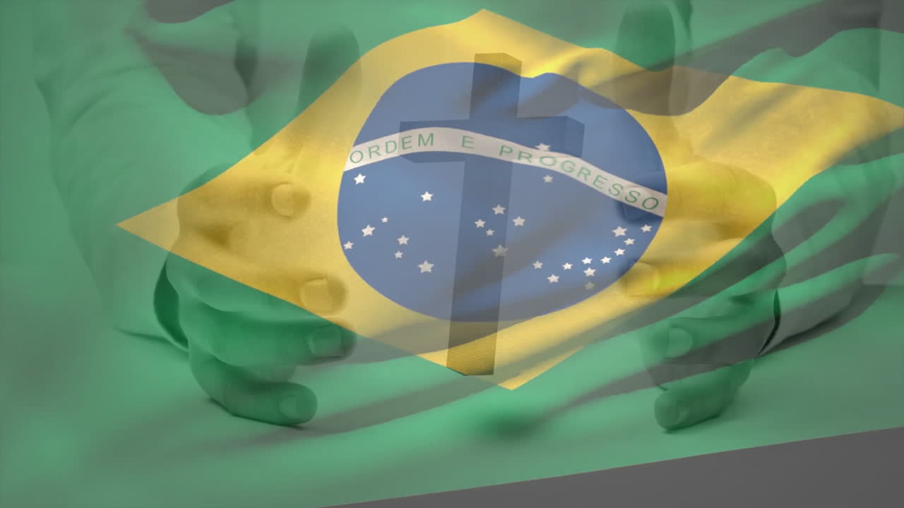Holding Brazilian flag with Ordem e Progresso text, hands in focus
