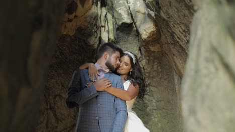 el novio con la novia de pie en la cueva de las colinas de la montaña.