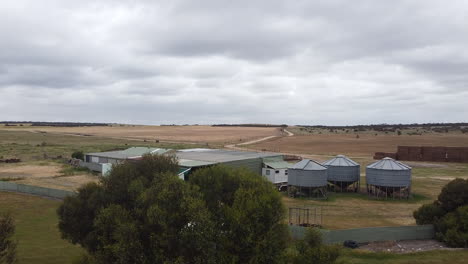 un petit silo de grain à côté d'un hangar de récolte sur une ferme